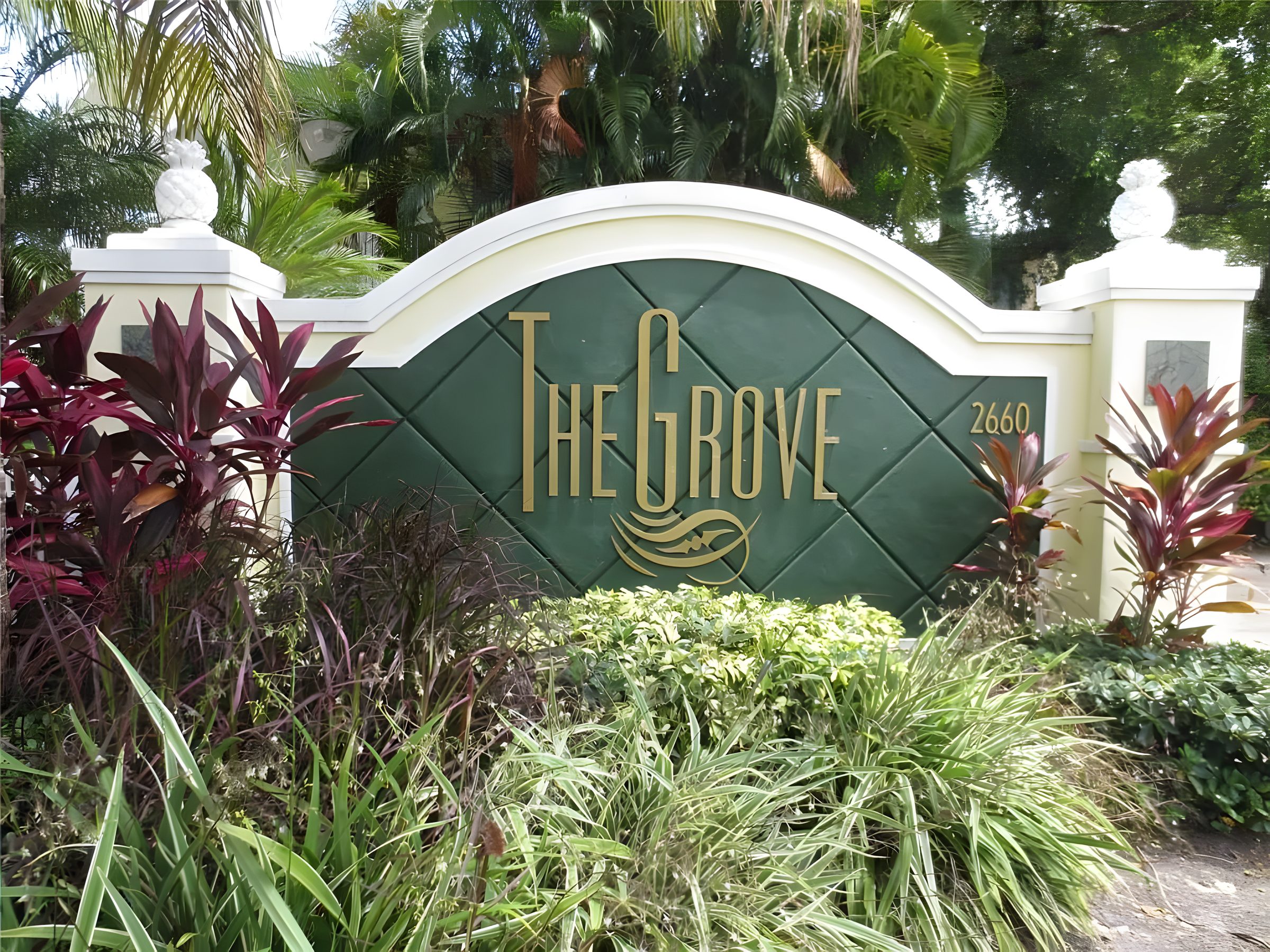 The Grove monument sign in deep green with the name in gold script and the street number.